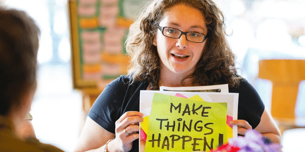 Woman holding 'Make things happen' sign