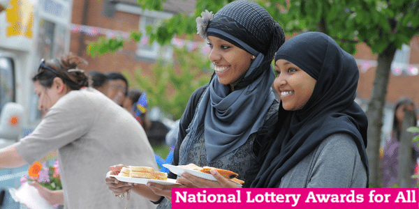 Two young women carrying food at Big Lunch with title text: Awards for All 