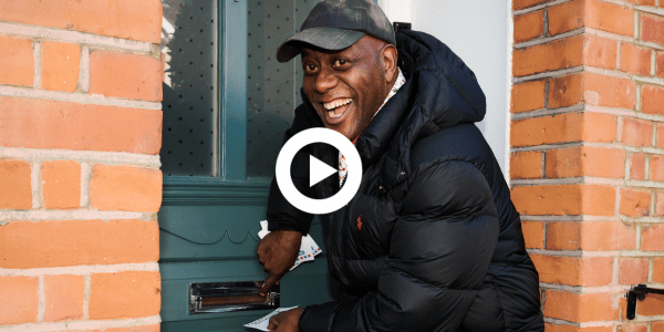 Ainsley Harriot putting an invite through letterbox
