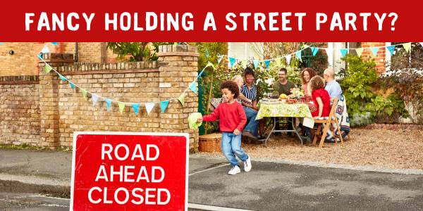 Neighbours enjoying a Big Lunch at a table in front garden with 'road ahead closed' sign and text: 'Fancy holding a street party?'