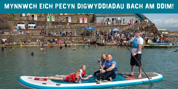 Big Lunch on a boat with smiling participants and text: 'Mynnwch eich pecyn digwyddiadau bach am ddim!