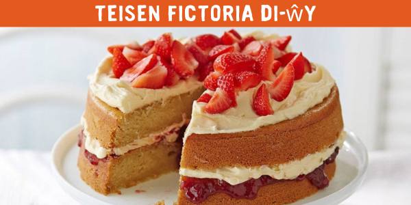 Victoria sponge cake with strawberries and text: 'Teisen fictoria di-wy'
