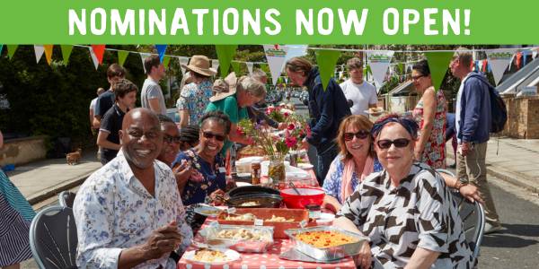 Ainsley Harriett and Jo Brand sitting at Big Lunch in a street with bunting and text: 'Nominations now open!'