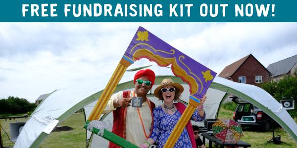 Man and woman smiling at a Big Lunch with text: 'Free fundraising kit out now!'