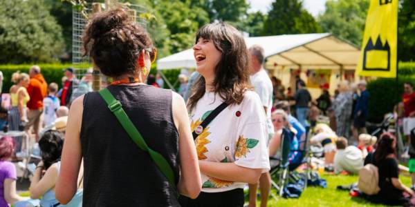 Two women laughing at an outdoor community event