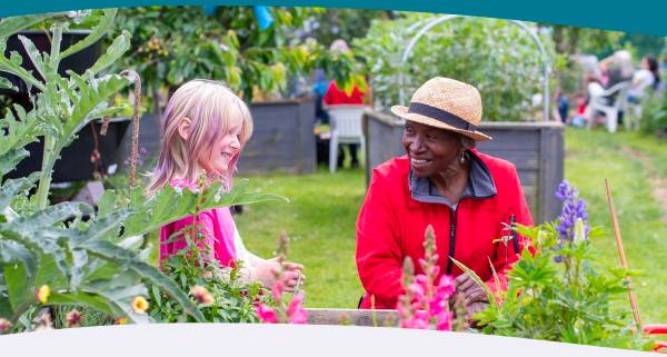Older lady and young girl smiling in a community allotment 