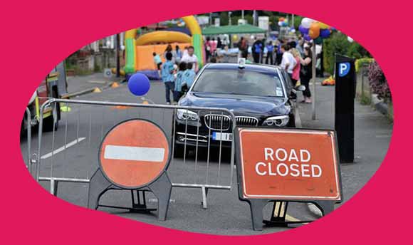 street party with 'road closed' and no entry signs in front of barrier 