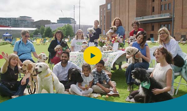Film still showing dogs and their owners at a Big Lunch launch event outside Battersea Power Station, London