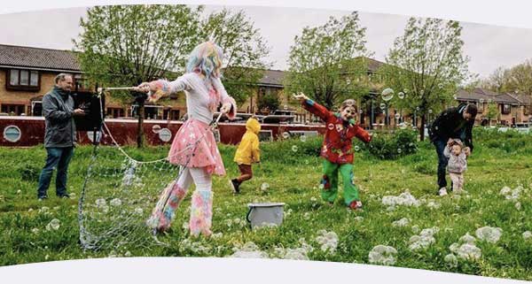 Children playing outside with giant bubbles