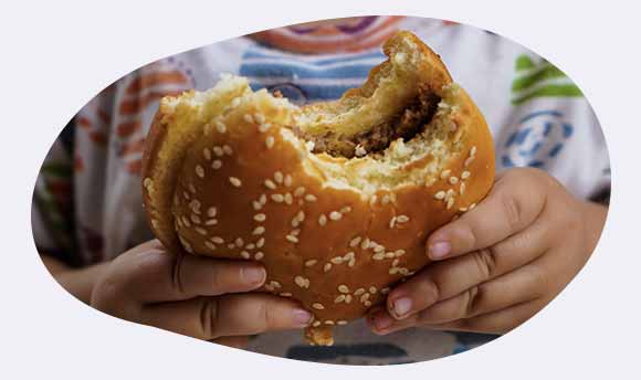 Child's hands holding a burger