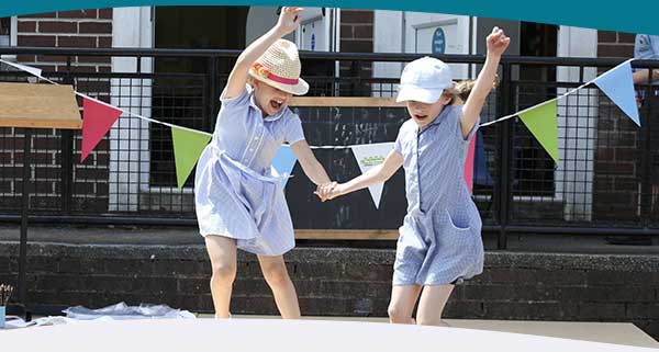 Two children jumping in the air at a Big Lunch event